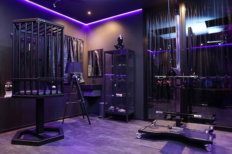 Innenraum eines lesbischen BDSM Studios in München mit dunkler Atmosphäre und moderner Beleuchtung.