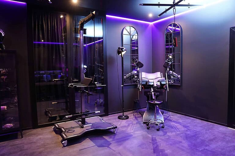 Alt: Hochwertiges BDSM Studio in München mit modernem Equipment und LED-Beleuchtung.