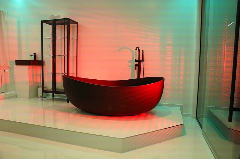Alt: Modernes BDSM Studio in München mit luxuriöser Badewanne, stimmungsvollem Licht und exklusivem Ambiente.