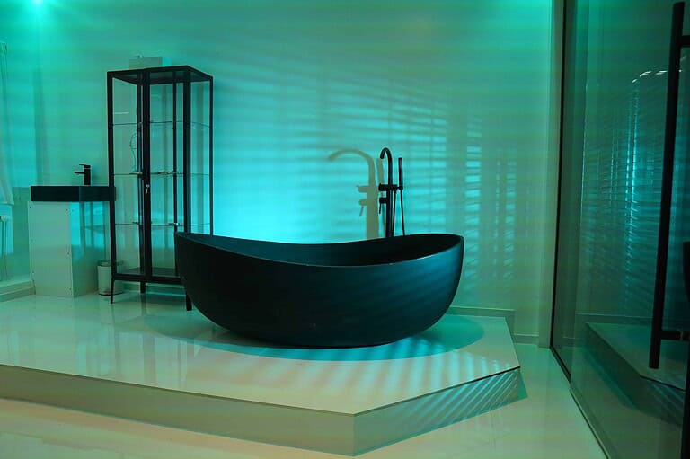 Helles, modernes Badezimmer mit freistehender Badewanne, Duschkabine und stilvollen Ornamenten, perfekt für BDSM-Erlebnisse in München.