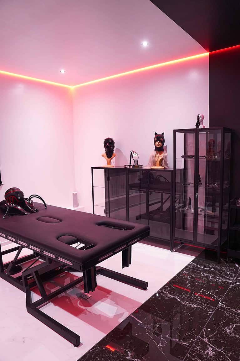 Hochwertiger BDSM Studio Raum mit stilvoller Dekoration und Sicherheitsausrüstung.