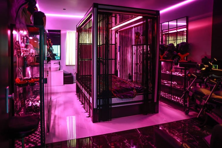 Hochsicherer BDSM Hotel Raum in München, mit Industrie Design und intensiven Pink-Licht.