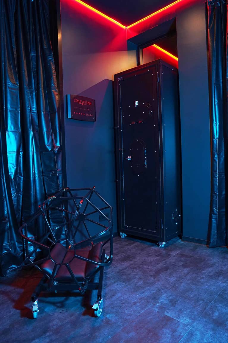 Hintergrund: Raum im BDSM Hotel München mit stilvollem Design, Fesselstangen und stilvollem Interieur.