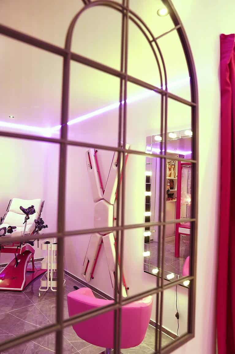BDSM Zimmer mit pinken Akzenten, Spiegel, Beleuchtung und exklusivem Design in München.